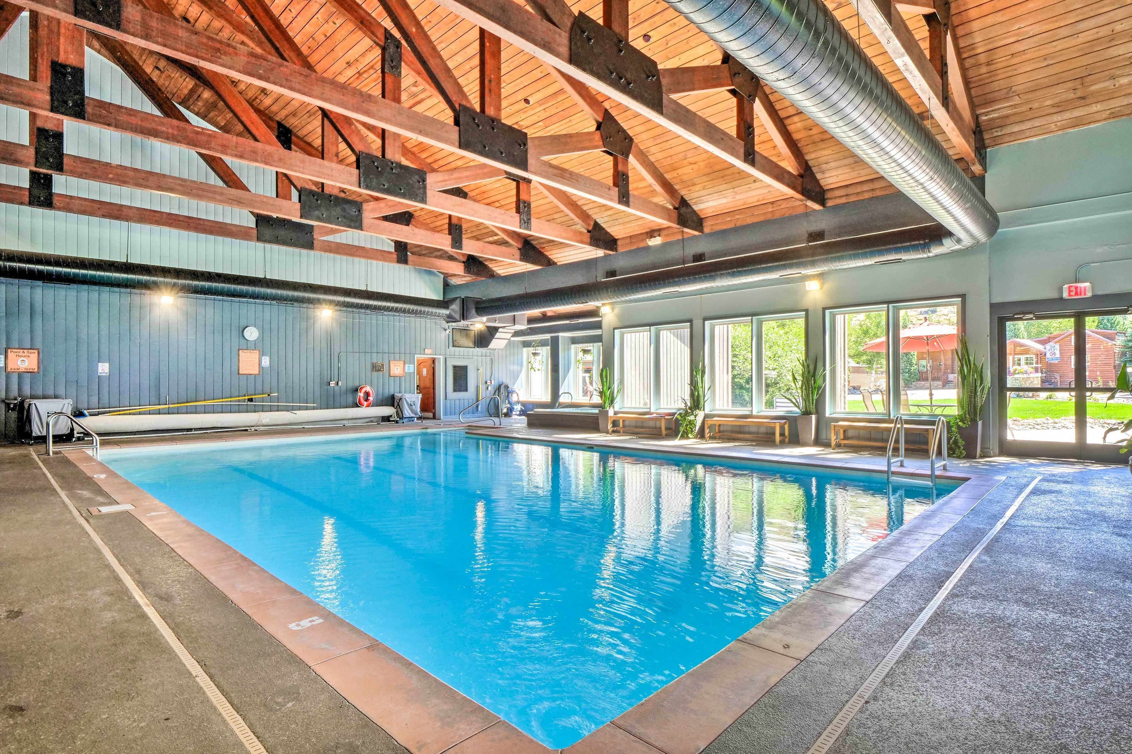 Ein Hallenbad mit Holzbalkendecke und großen Fenstern.