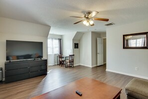 A spacious living room with a flat-screen TV, a wooden coffee table, and a ceiling fan. - Quiet Oasis in Charlotte! Home Near Uncc Campus (Charlotte)