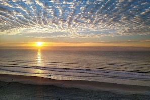 Een strand met een zonsondergang en golven.