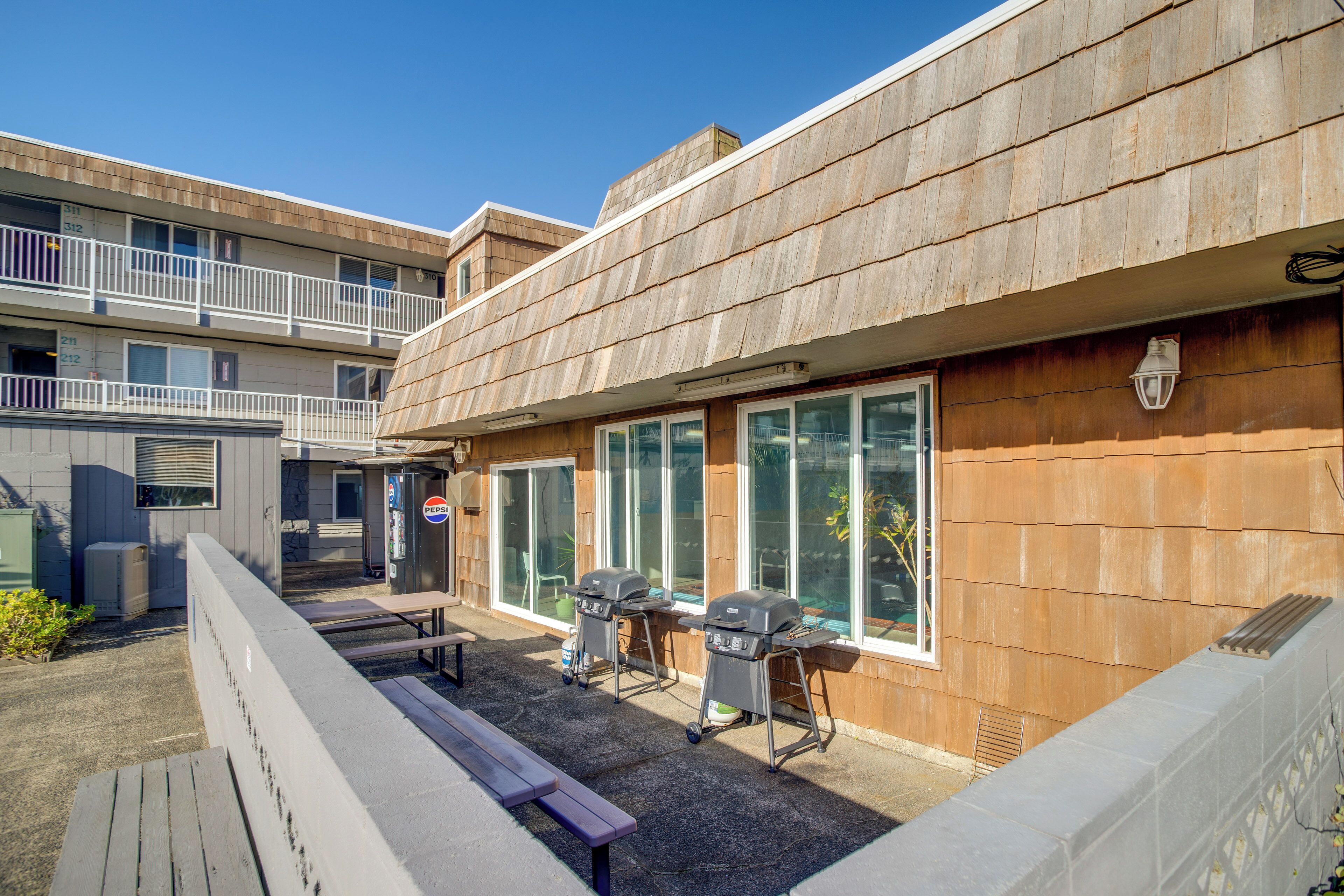 Une cour avec des espaces de détente en plein air et des barbecues.