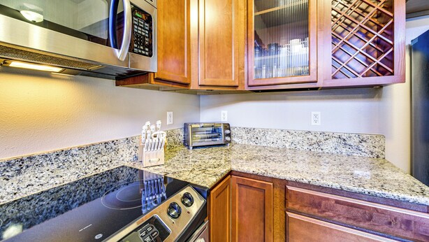 A kitchen with granite countertops, wooden cabinets, a microwave, a toaster, and a stainless steel range hood. - 4 Mi to Dtwn, Commuter-friendly Apt in Tacoma (Tacoma)