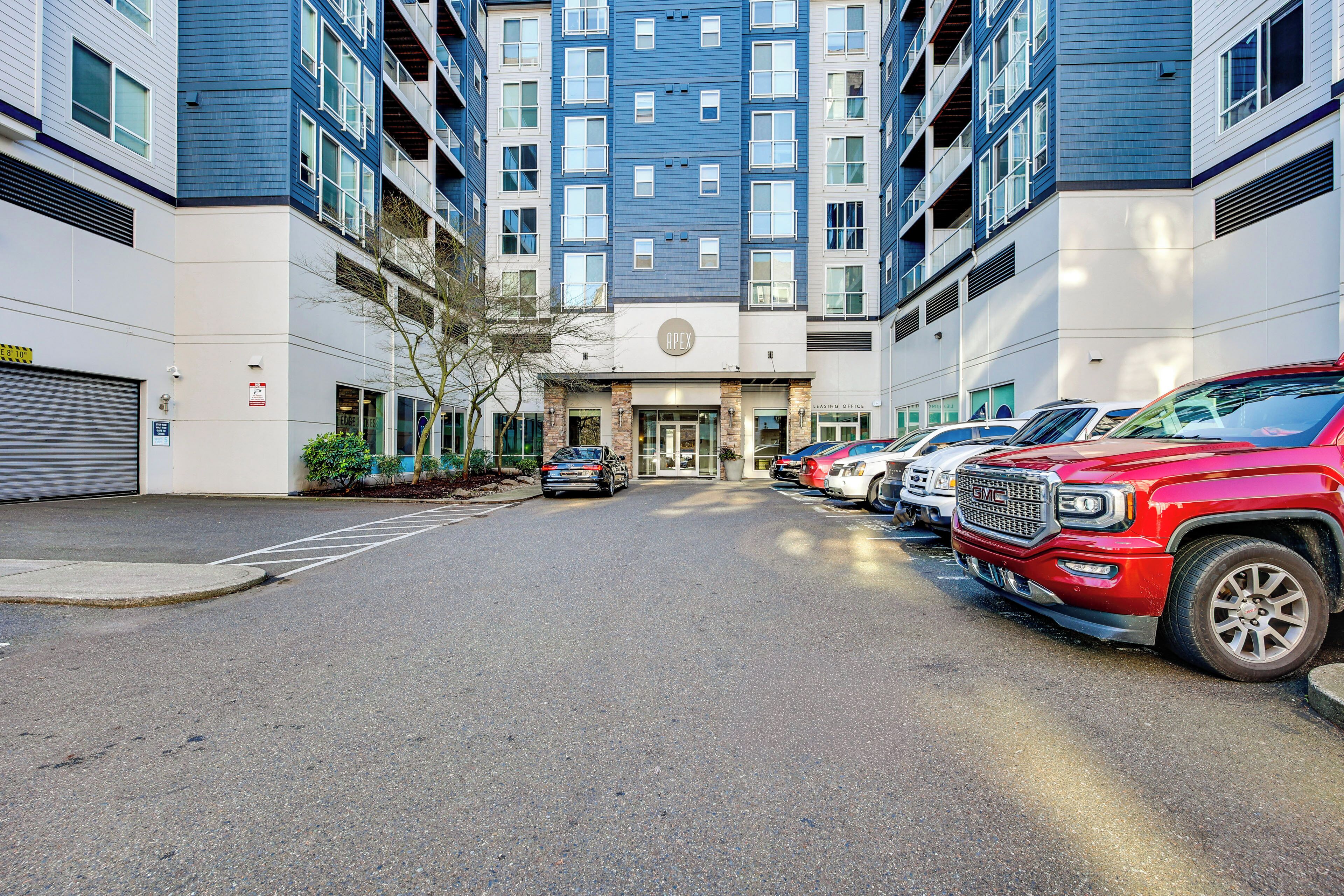 A multi-story building with a parking lot in front.