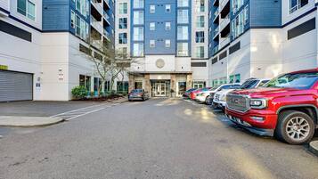 A multi-story building with a parking lot in front.