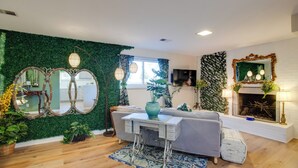 A living room with a green wall, a sofa, a coffee table, and a fireplace. - Work & Play Near Old Town Arvada: Pets Welcome! (Arvada)