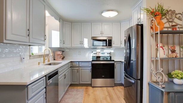 A modern kitchen with white cabinets, stainless steel appliances, and a wooden floor. - 2 Mi to Old Town: Pet-friendly Home Base in Arvada (Arvada)