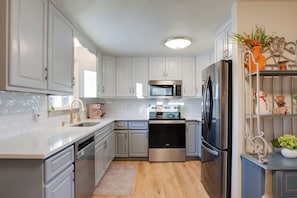 A modern kitchen with white cabinets, stainless steel appliances, and a wooden floor. - 2 Mi to Old Town: Pet-friendly Home Base in Arvada (Arvada)