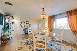 A dining area with a round table, white chairs, a patterned rug, and a chandelier. - 2 Mi to Old Town: Pet-friendly Home Base in Arvada (Arvada)