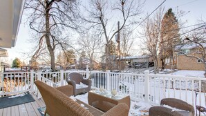 A covered outdoor deck with wicker furniture and a white fence. - 2 Mi to Old Town: Pet-friendly Home Base in Arvada (Arvada)