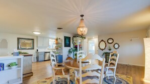 A dining area with a wooden table, white chairs, and a patterned rug. - 2 Mi to Old Town: Pet-friendly Home Base in Arvada (Arvada)