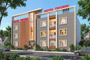 Un moderno edificio di un hotel con un cartello ben visibile che riporta 'HOTEL TRIVENI'.