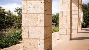 Eine Steinstruktur mit flachem Dach und Säulen, vermutlich Teil eines historischen Gebäudes oder Monuments.