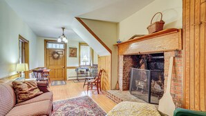 Una sala de estar acogedora con chimenea, muebles de madera y un comedor con mesa y sillas.