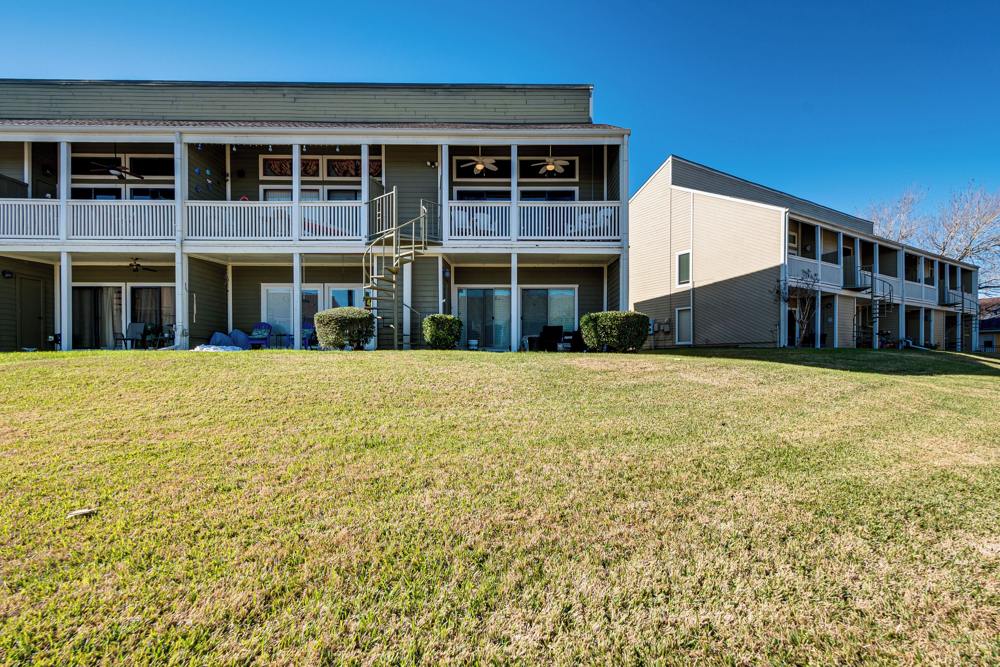 A two-story motel with a central staircase, a covered front porch, and a well-maintained lawn.