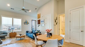 A spacious living room with a blue sofa, a wooden coffee table, and a dining area with a round table and chairs. - Lake Greenwood Access: Modern Escape w/ Patio! (Greenwood)