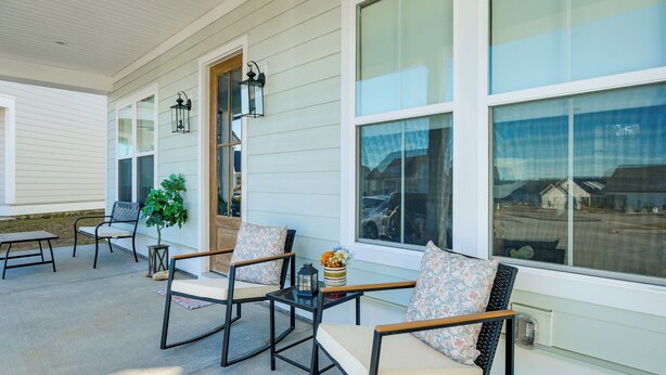 A covered porch with outdoor seating, large windows, and a potted plant. - Lake Greenwood Access: Modern Escape w/ Patio! (Greenwood)