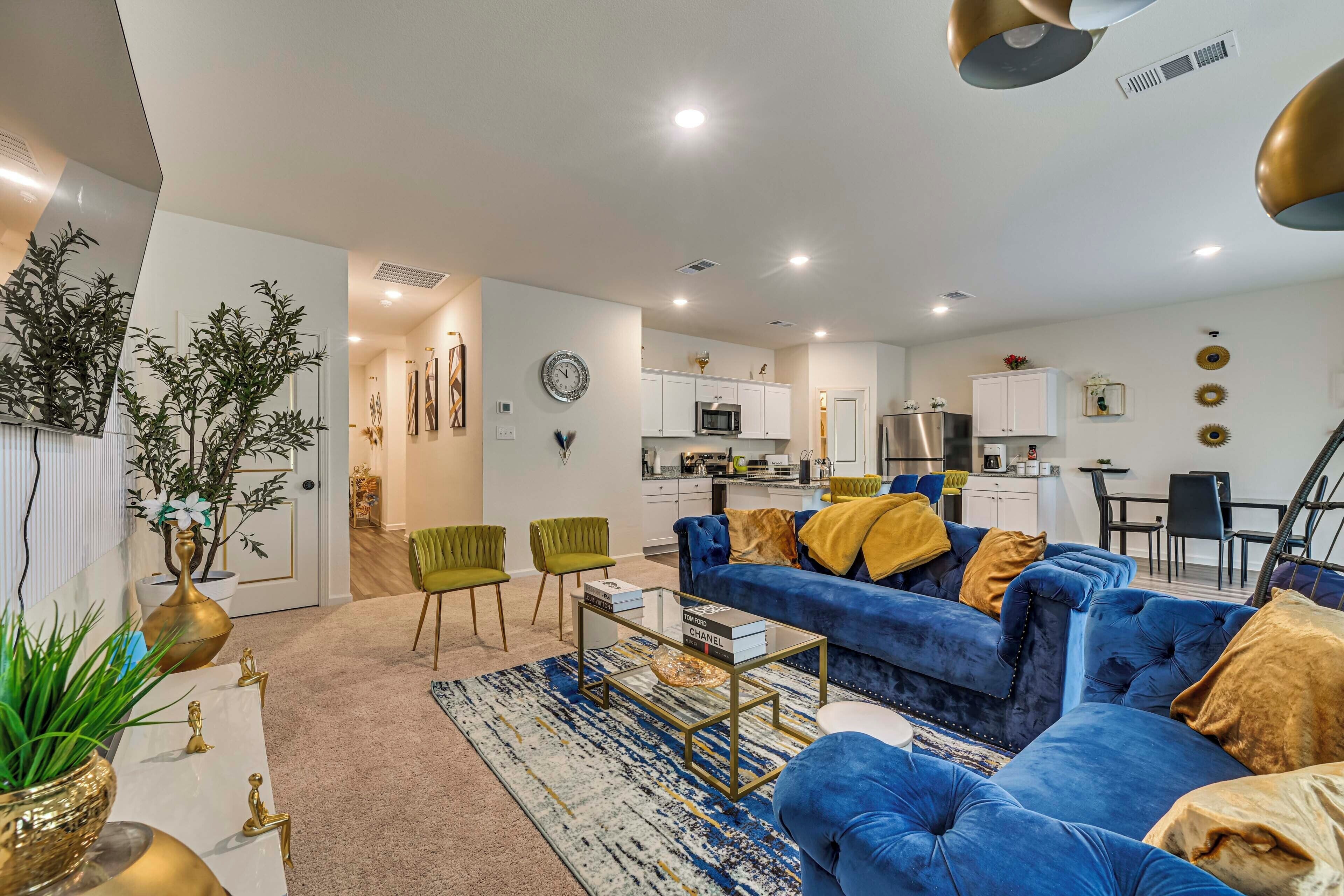 A modern living room with a blue sofa, green chairs, and a coffee table.