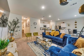 A modern living room with a blue sofa, green chairs, and a coffee table. - Group Haven in Princeton! WFH Ready & Ample Space (Princeton)