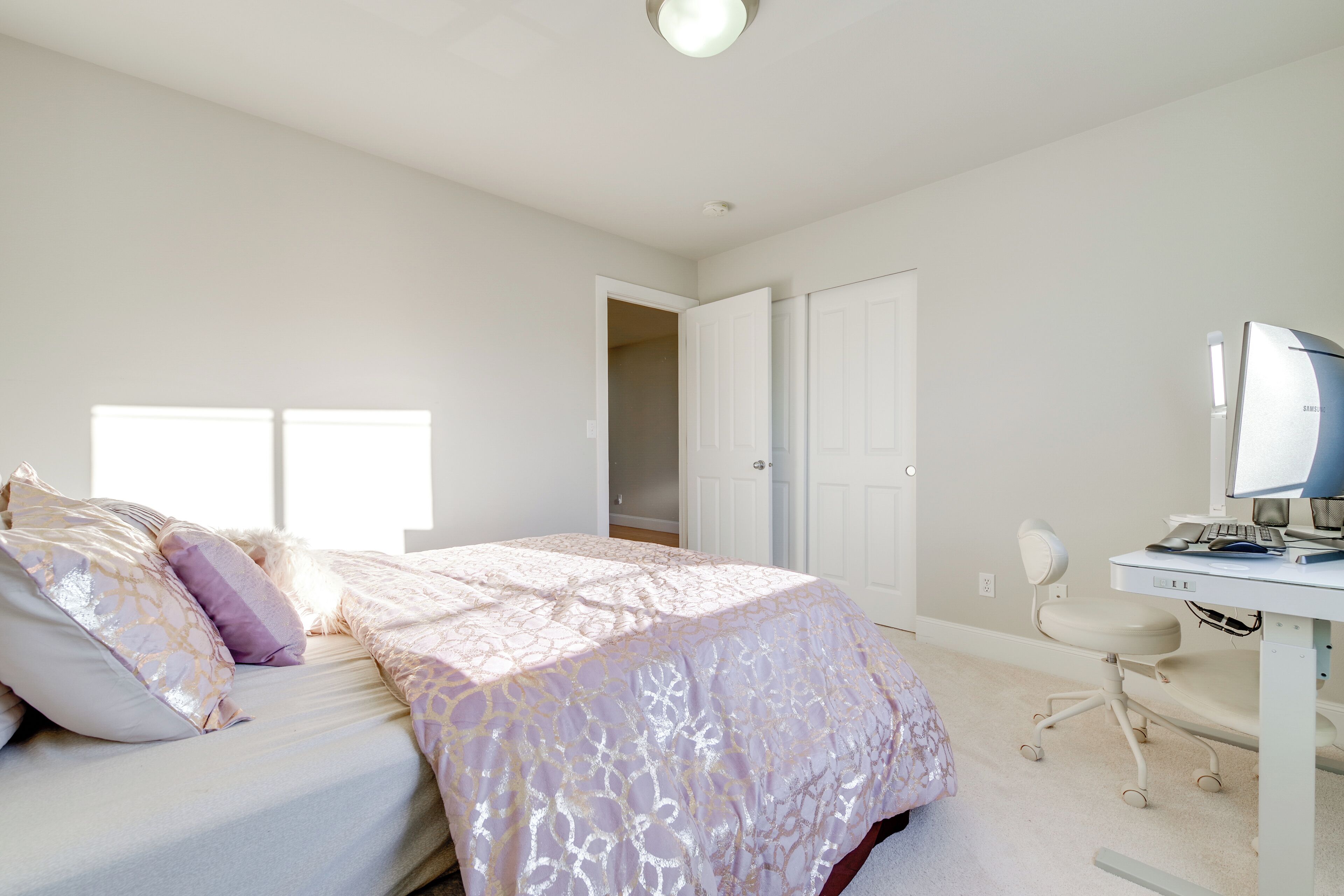 Un dormitorio con una cama, un escritorio y una silla.