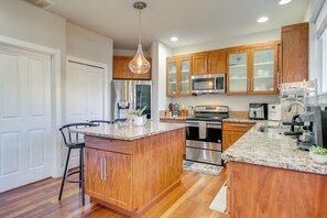 A modern kitchen with wooden cabinets, stainless steel appliances, and a granite countertop. - Gateway to Seattle! Lynnwood Home w/ Gazebo & Yard (Lynnwood)