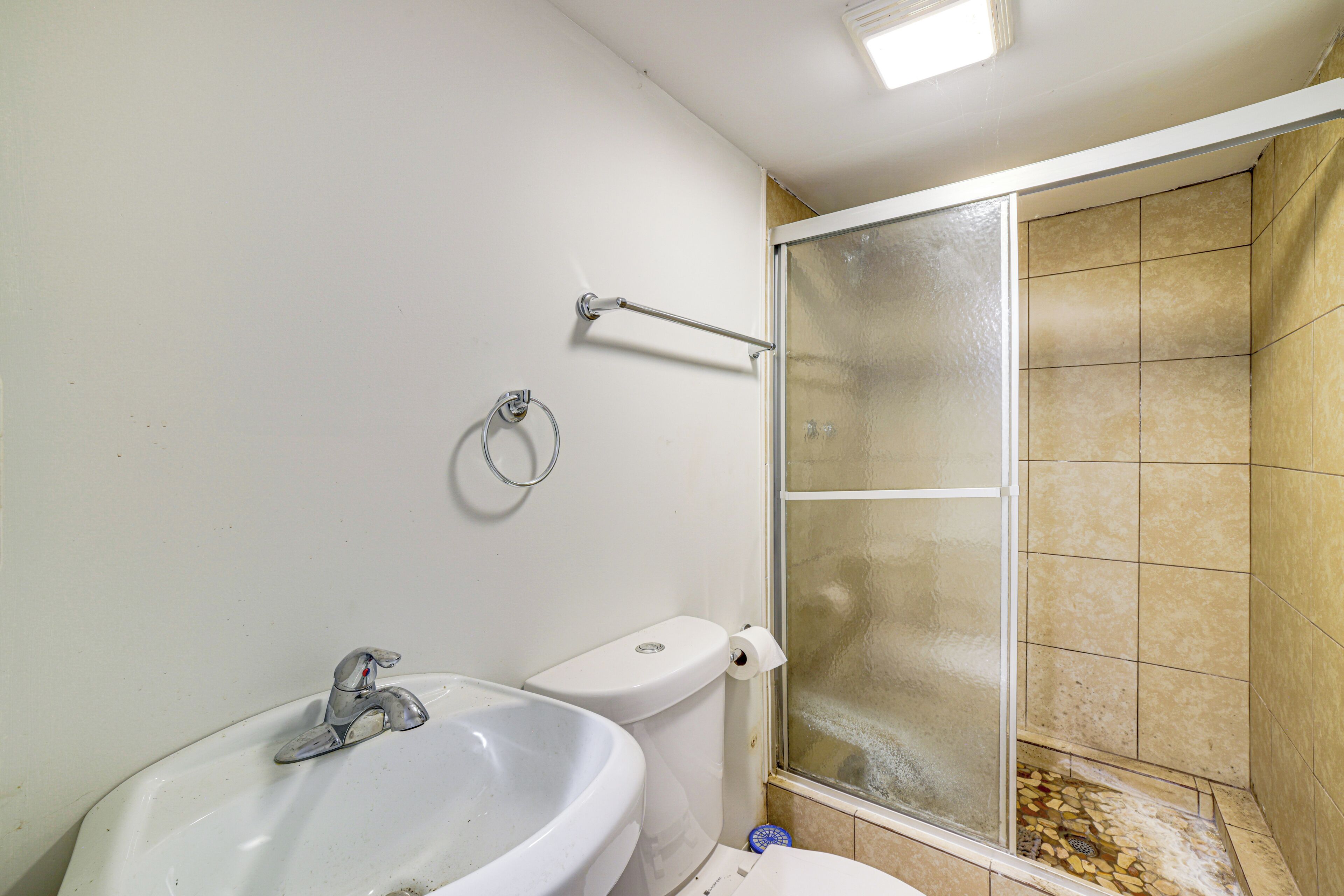 A bathroom with a sink, toilet, and a glass shower enclosure.