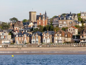 A coastal town with historic buildings, a prominent church tower, and a beach in the foreground. - Bright apartment near the beach in Villers-sur-Mer (Villers-sur-Mer)