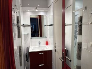 A modern bathroom with a glass shower enclosure, a white sink, and a mirror above it. - Air-conditioned villa with parking for 2 people in Cap d'Agde (Cap d'Agde)
