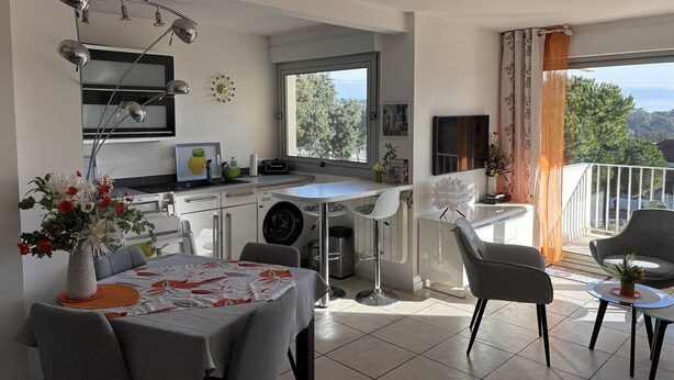 A modern kitchen with a dining area, a washing machine, and a balcony with a view. - Charming T2 in Saint-Palais-sur-Mer, near Nauzan beach, private box (Saint-Palais-sur-Mer)