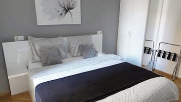 Une chambre à coucher avec un lit, une armoire et un miroir.