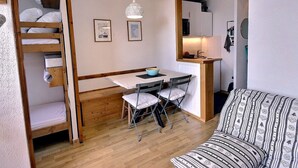 A compact room with a bunk bed, a small desk with a chair, a kitchenette, and a sofa. - Studio for 4 in Vallandry, terrace and near slopes (Peisey-Vallandry)