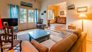 A living room with a sofa, coffee table, TV, and a dining area with chairs and a table. - ARCACHON, LES ABATILLES : A 450 M DE LA CELEBRE SOURCE DES ABATILLES ! (Arcachon)