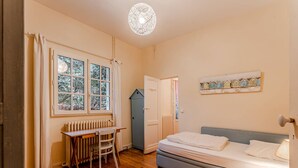 A bedroom with a wooden floor, a bed, a desk, and a radiator. - ARCACHON, LES ABATILLES : A 450 M DE LA CELEBRE SOURCE DES ABATILLES ! (Arcachon)