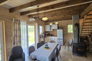 A wooden interior with a dining area, kitchen, and a fireplace. - Large Holiday Home, Salt Cave, Sauna, Jacuzzi (Lipusz)