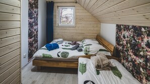 A bedroom with a wooden bunk bed and a single bed, both with leaf-patterned bedding. - Large Holiday Home, Salt Cave, Sauna, Jacuzzi (Lipusz)