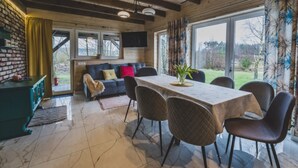 A dining area with a table, chairs, and a view of the outdoors. - Large Holiday Home, Salt Cave, Sauna, Jacuzzi (Lipusz)
