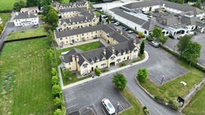 A residential area with multiple two-story houses, a parking lot, and a green field in the background. - No 27 Killarney Holiday Village - Great Location (Killarney)