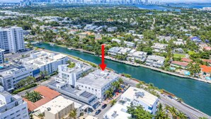 An aerial view of a coastal city with a river running through it, modern buildings, and a prominent red arrow pointing to a specific location. - Miami Beach Escape Inviting Studio (Miami Beach)