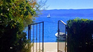 A coastal scene with a clear view of the sea, a boat, and a sailboat in the distance. - Adorable 1-bedroom apartment in charming Dugi Rat (Dugi Rat)