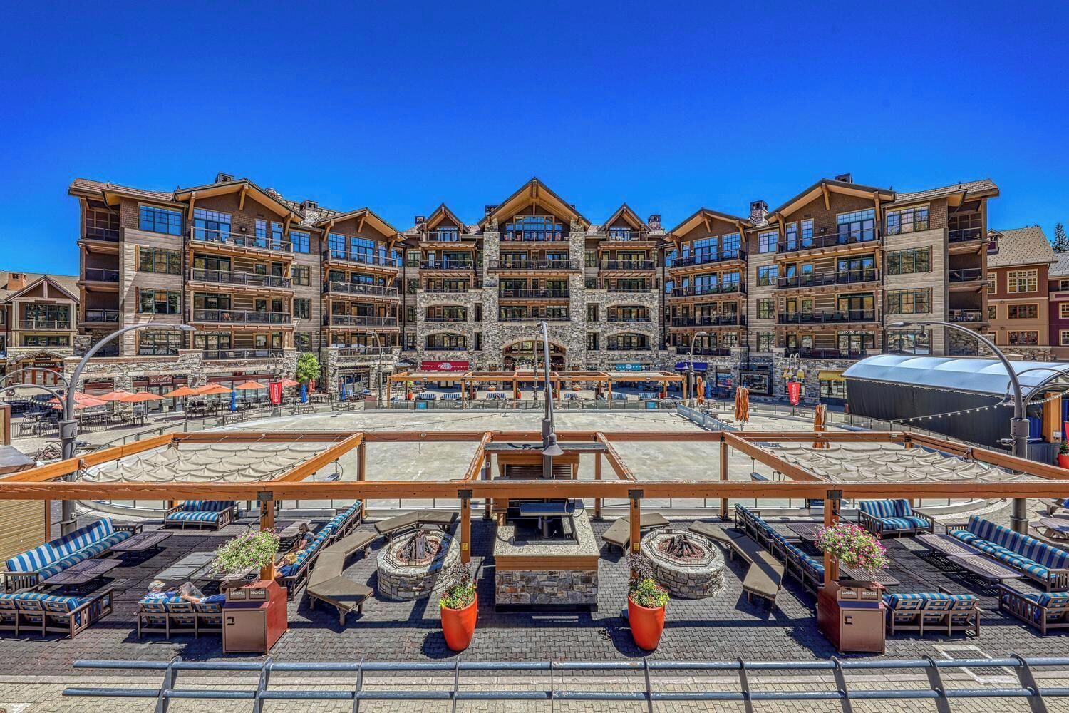 Un hotel de varios pisos con zonas de estar al aire libre y una chimenea.