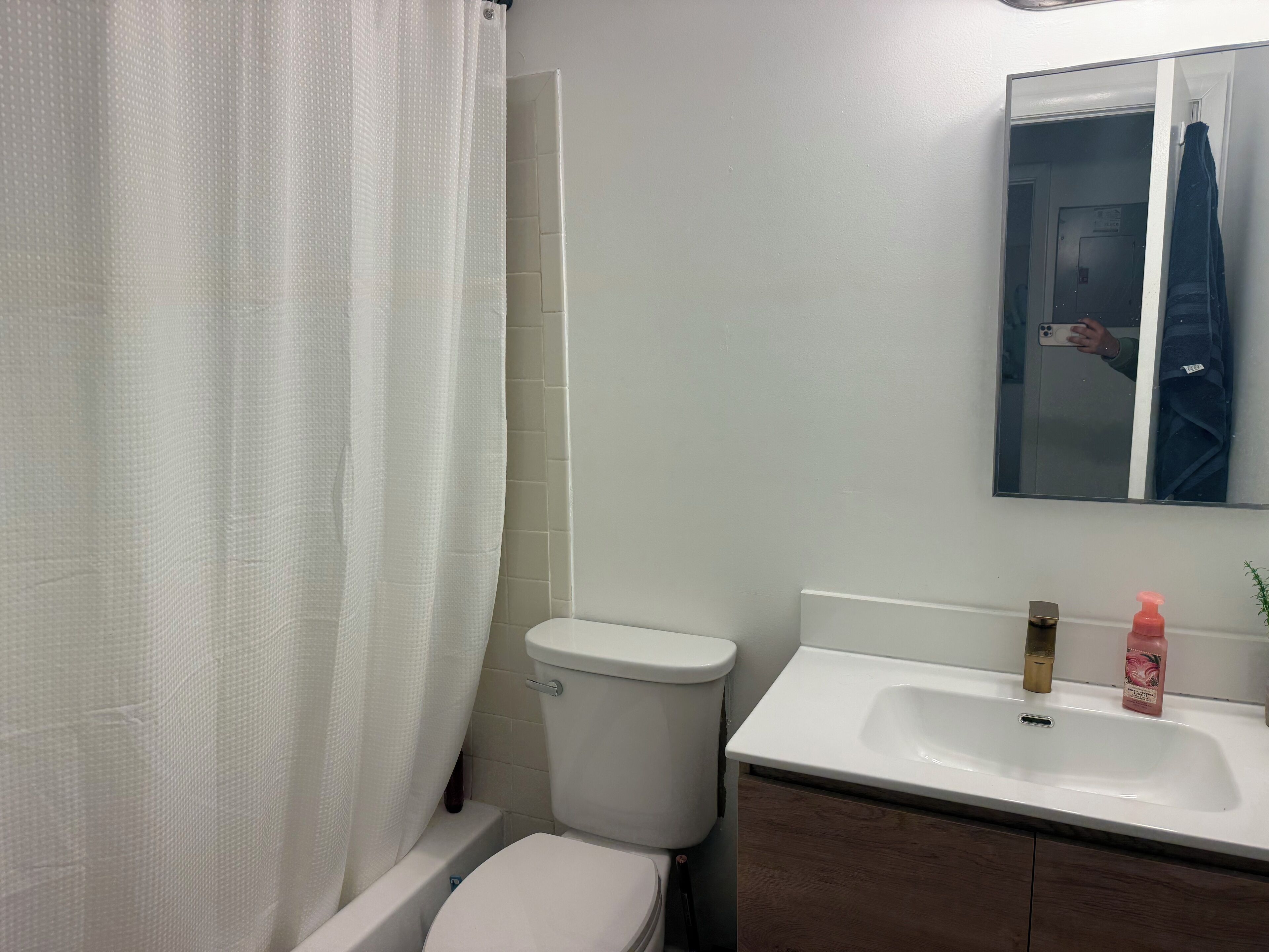 Une salle de bain avec des toilettes, un lavabo et un miroir.