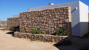A building with a stone facade and a white exterior wall. - |    Rania Villas   | (Kipi Afiarti)