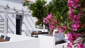 Un edificio blanco con un patio, una mesa y sillas.