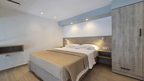Un dormitorio moderno con una cama grande, mesitas de noche, un armario e iluminación empotrada en el techo.