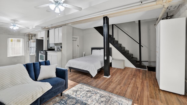 Un loft spacieux comprenant un grand lit, un canapé, un coin repas et une cuisine.