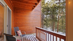 A wooden deck with two chairs and a bench, overlooking a forested area. - 97 Lookout Ridge 2 Bedroom Townhouse (Dillon)