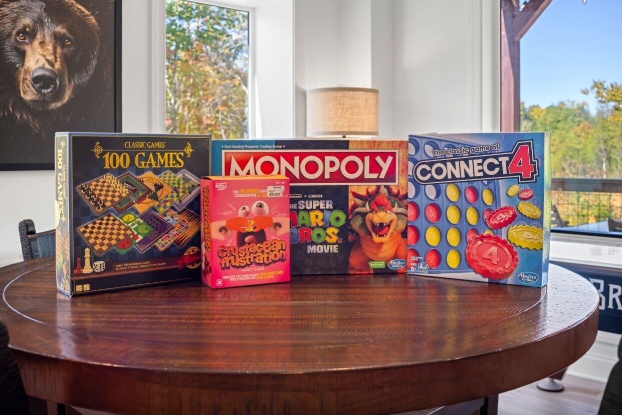 Quatre jeux de société sur une table en bois.