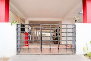 A gated entrance to a building with a red and white facade. - Hotel O Coimbatore International Airport (Coimbatore)