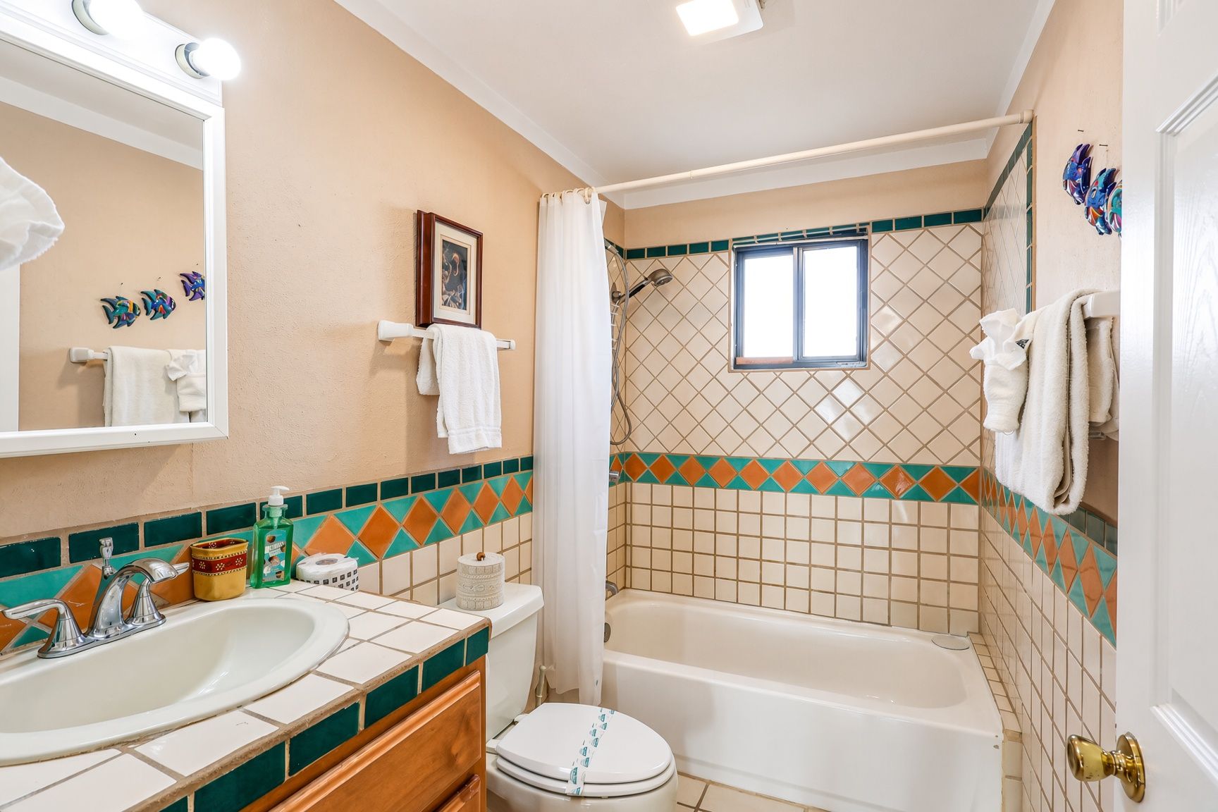Ein Badezimmer mit Waschbecken, Toilette, Badewanne und Duschbereich.