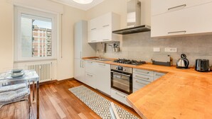 Eine moderne Küche mit weißen Schränken, einer Holz Arbeitsplatte und einem eingebauten Backofen.