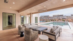 A modern outdoor living area with a pool, comfortable seating, and a view of the surrounding landscape. - Sleeps 58! Parade Home! 30 Person Spa! (St. George)