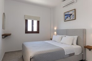A bedroom with a bed, a window, a painting, and a wall-mounted air conditioner. - One Bedroom Apartment-sleeps 4 -sea View-parking (Pyrgos)